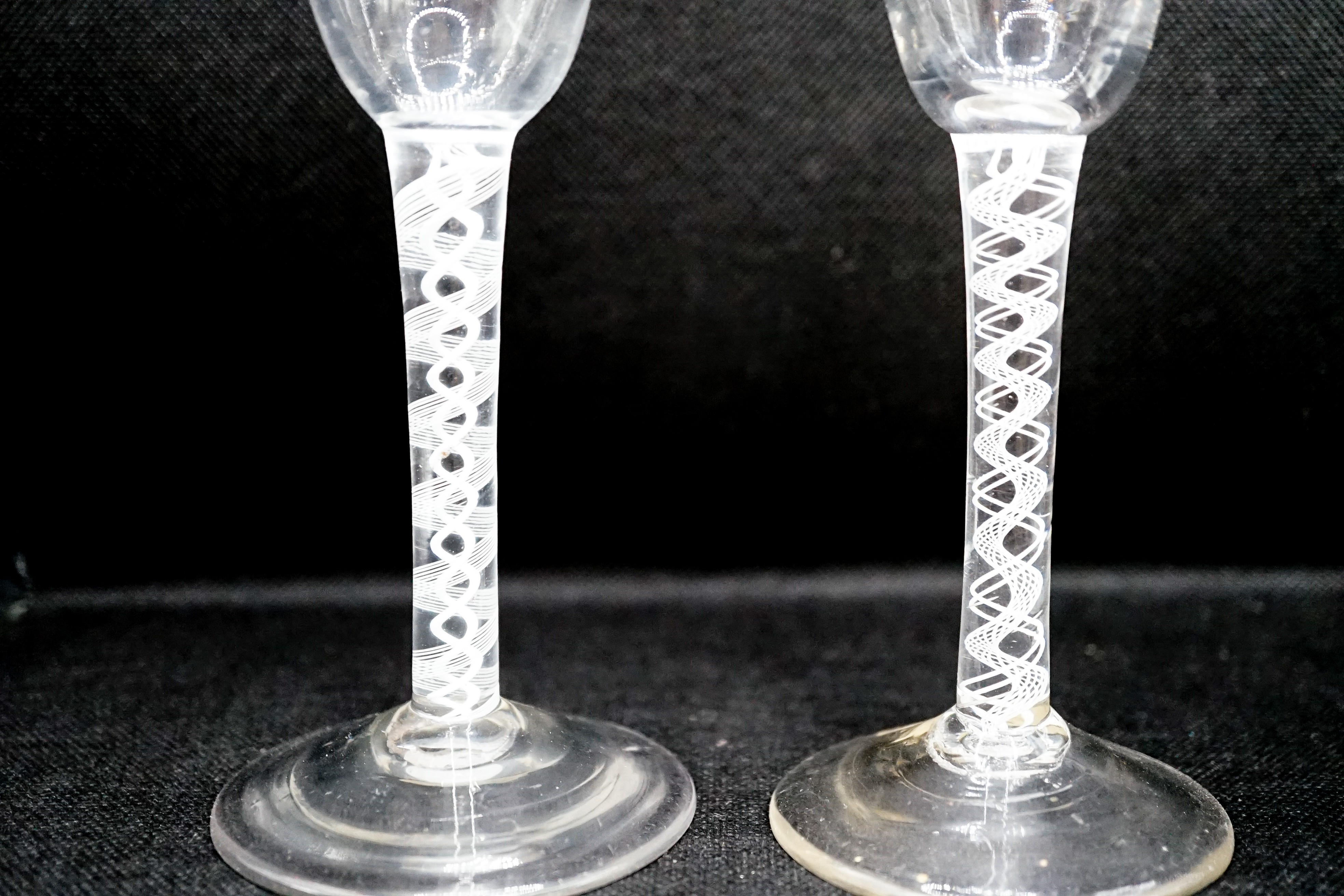Two George III double series opaque twist stem cordial glasses, c.1765, each with a funnel shaped bowl, 15cm